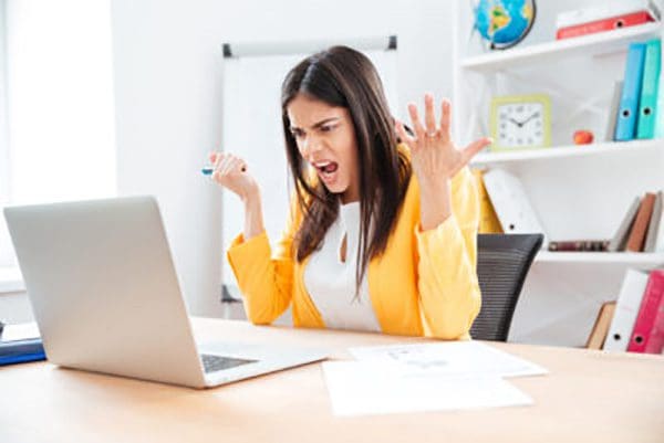 Woman looking frustrated while sitting at her computer