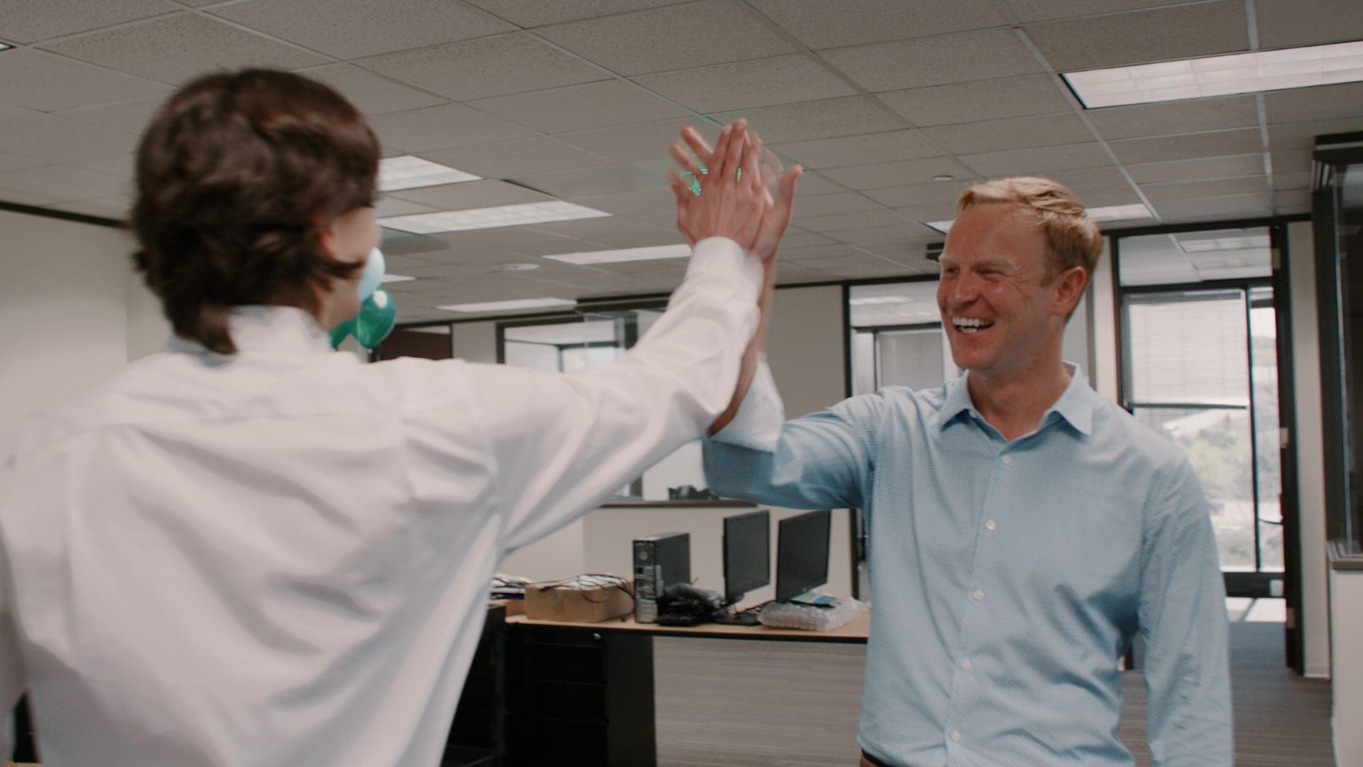 Two Bridgepoint colleagues high-fiving in the Bridgepoint office