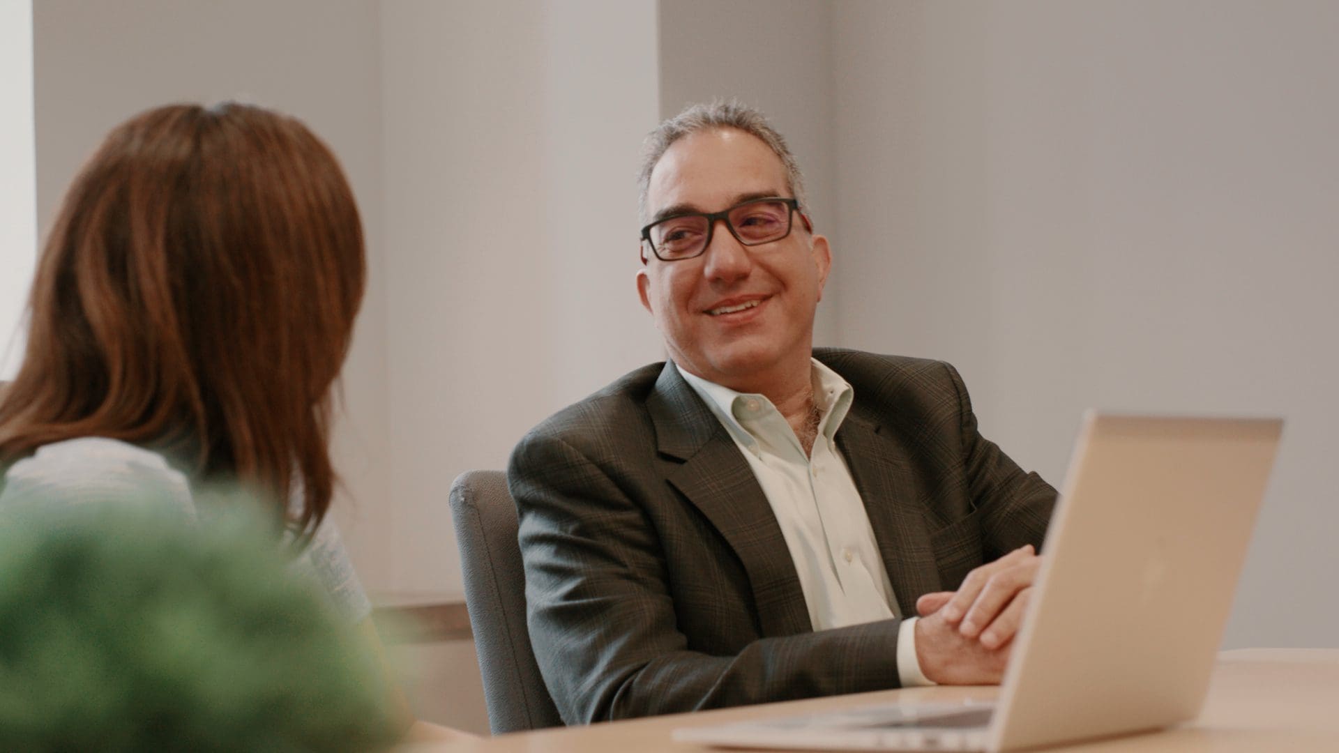 Man in Suit Smiling with Women listening at Bridgepoint Office