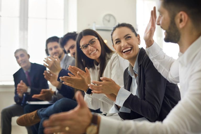 Group of people thanking speaker for interesting presentation in professional business conference or seminar. Team of happy male and female company workers applauding colleague in corporate meeting