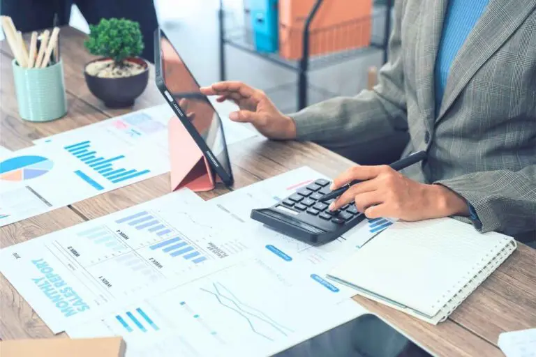 Woman budget planning at her desk with calculator and financial documents.