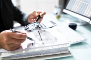 Audit And Fraud Investigation. Auditor Using Magnifying Glass