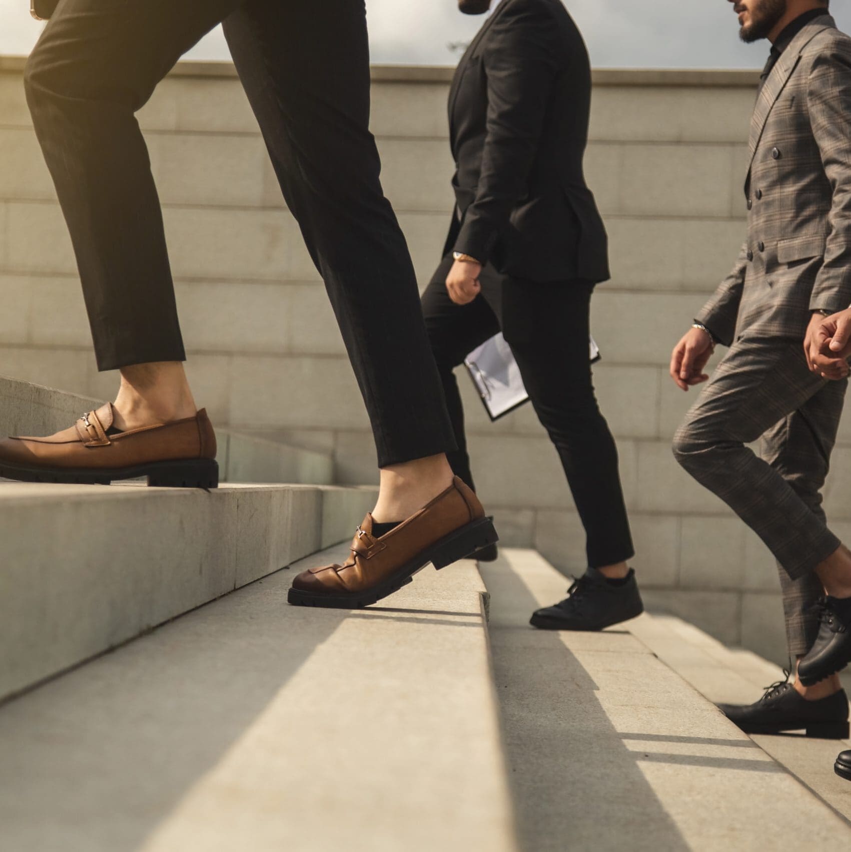 Three people walking up outdoor stairs, signifying advancement and success.