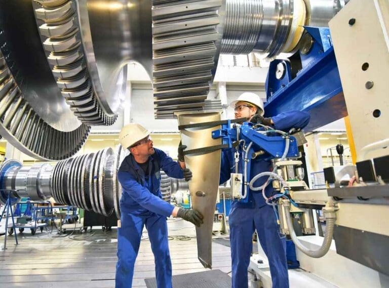 Two engineers working on a large tool.