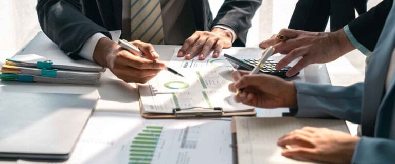 Three men reviewing financial statements