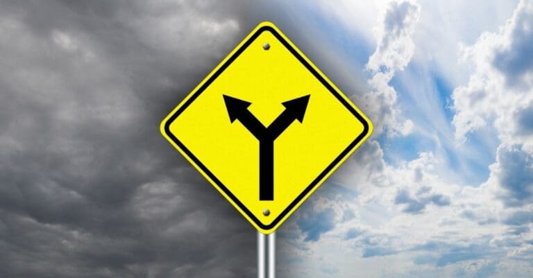 A yellow traffic sign depicting a fork in the road- one arrow points left supperimposed over grey clouds, the other arrow points right, superimposed over a blue sky.